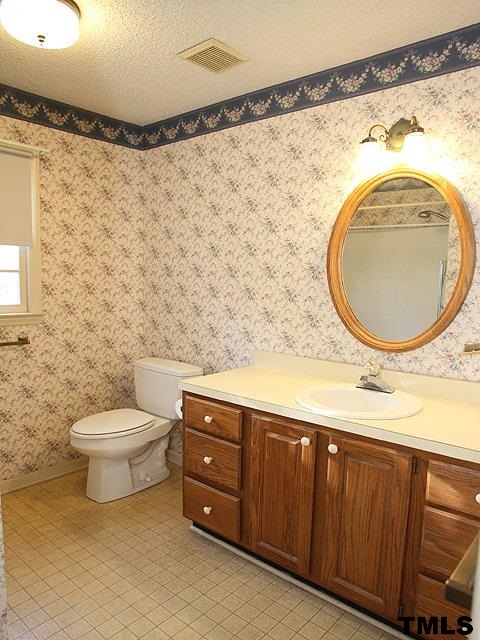 1213 Oakside Court Raleigh, NC 27609 - Photo 11 of 13 a bathroom with a sink and a mirror