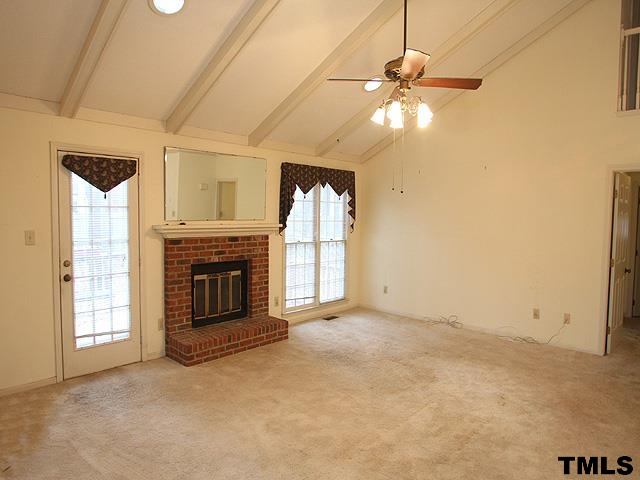 1213 Oakside Court Raleigh, NC 27609 - Photo 3 of 13 an empty room with windows and fireplace
