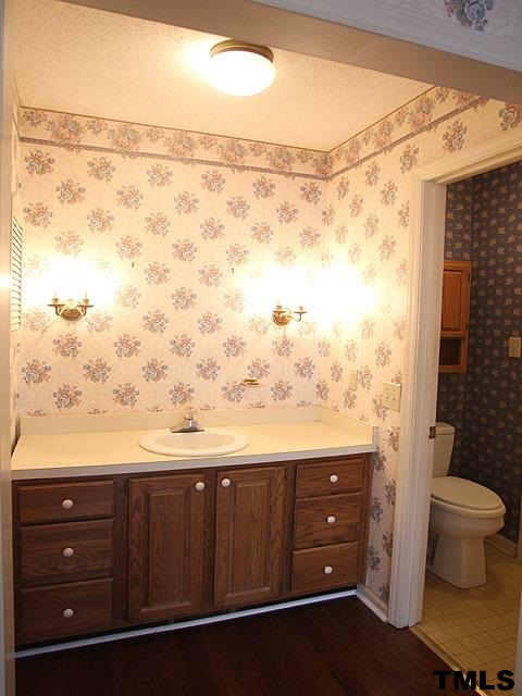 1213 Oakside Court Raleigh, NC 27609 - Photo 8 of 13 a bathroom with a granite countertop sink and a toilet