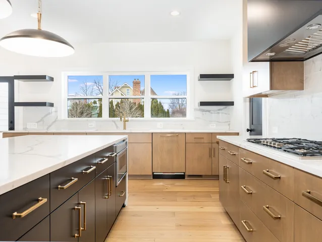 a kitchen with stainless steel appliances a stove and white cabinets