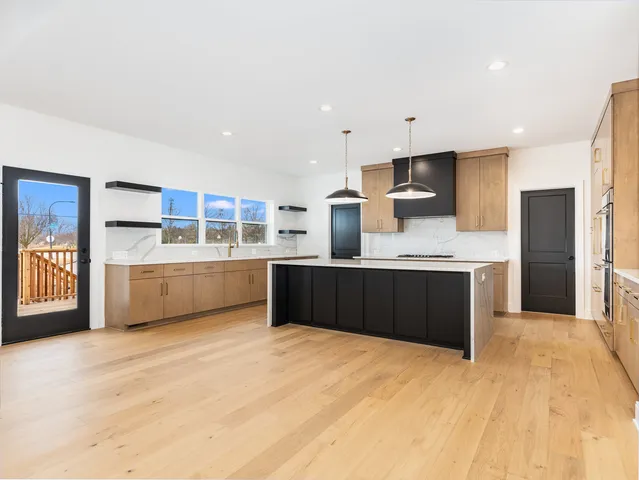a large kitchen with a large counter top stainless steel appliances and cabinets