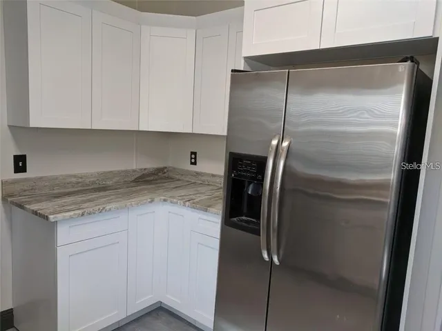 a kitchen with a refrigerator and cabinets