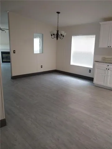 an empty room with windows and ceiling fan