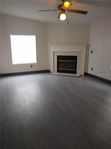 an empty room with windows and fireplace