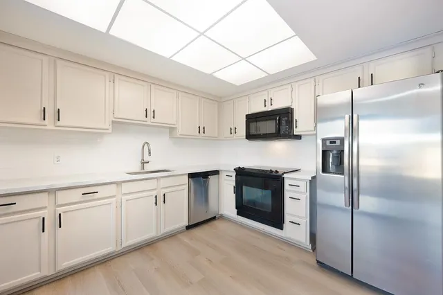 a kitchen with cabinets stainless steel appliances and a sink