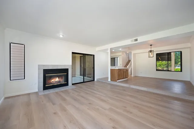 an empty room with windows and fireplace