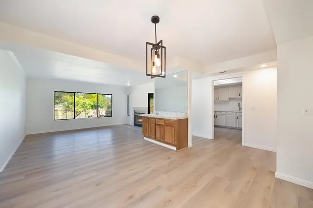 a view of empty room with wooden floor and window