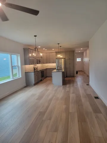 a view of a big room with wooden floor and a window