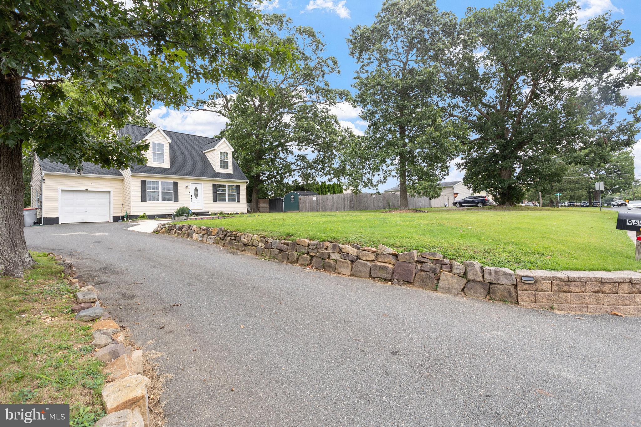 a view of a house with a yard and large trees