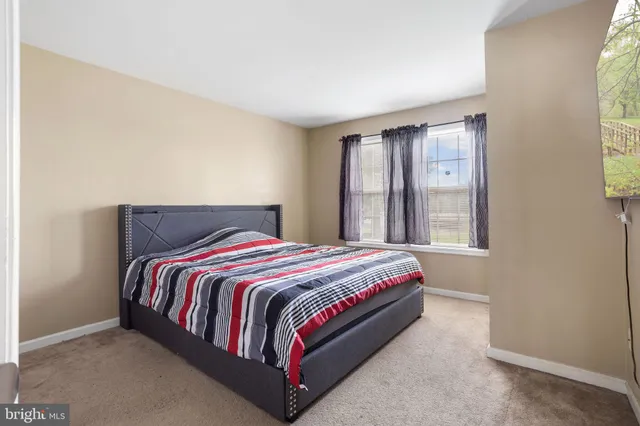 a bed sitting in a bedroom next to a window