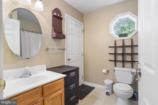 a bathroom with a granite countertop toilet sink and mirror