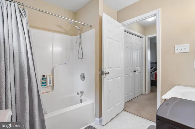 a bathroom with a tub shower vanity and a sink