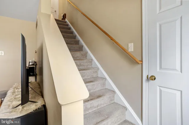 a view of staircase with white walls and railing