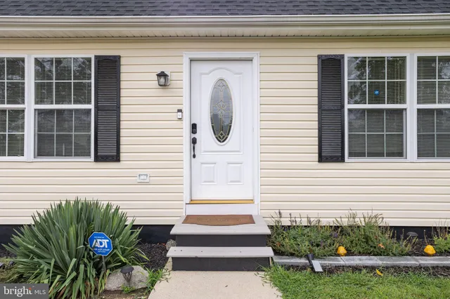 a front view of a house with a yard and potted plants