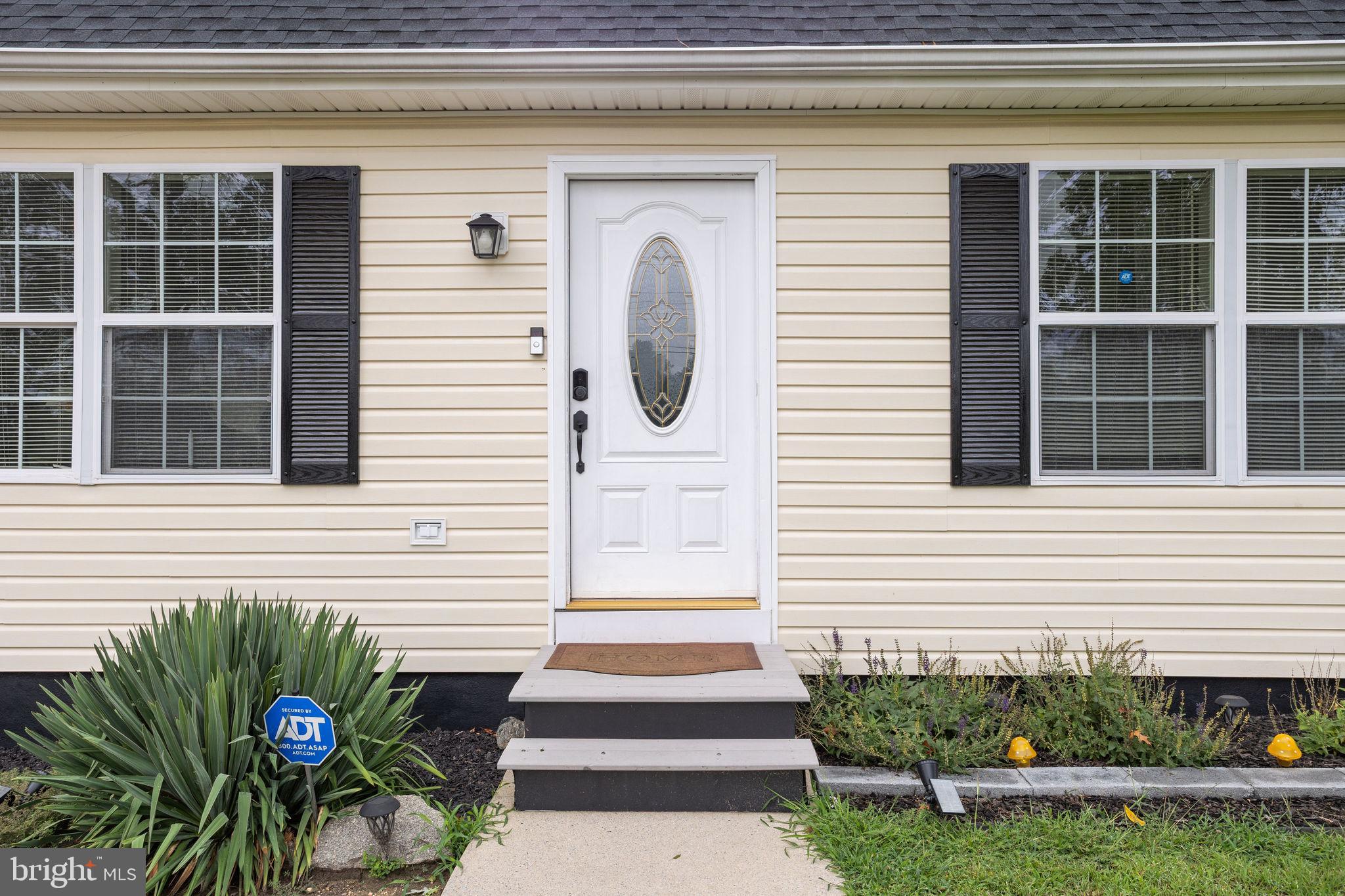 954 East Walnut Road Vineland, NJ 08360 - Photo 3 of 25 a front view of a house with a yard and potted plants
