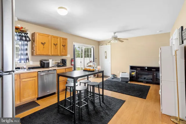 a kitchen with stainless steel appliances granite countertop a stove refrigerator and a table