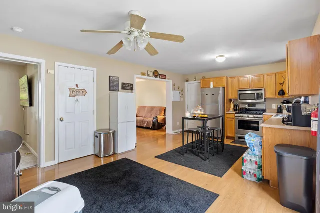 a living room with furniture and a dining table with wooden floor