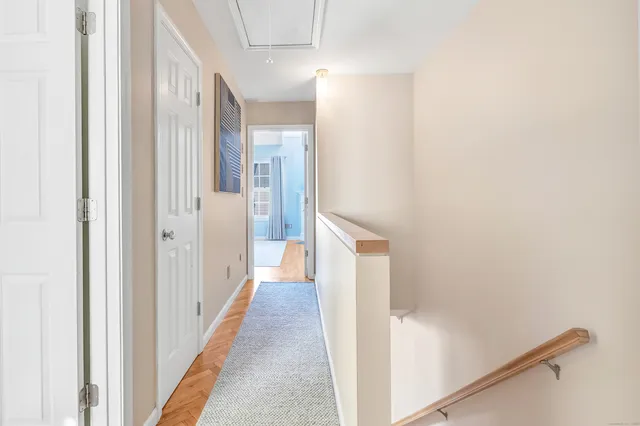 a view of a hallway with wooden floor