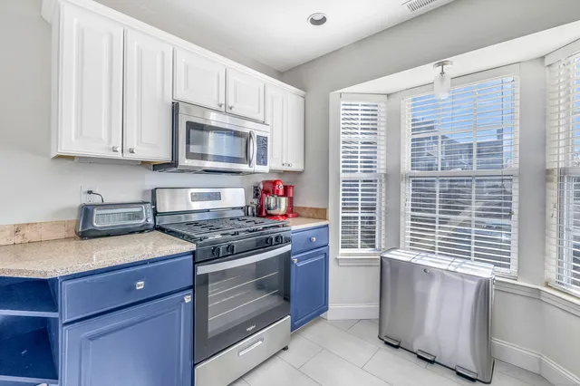 a kitchen with stainless steel appliances granite countertop a stove sink and cabinets