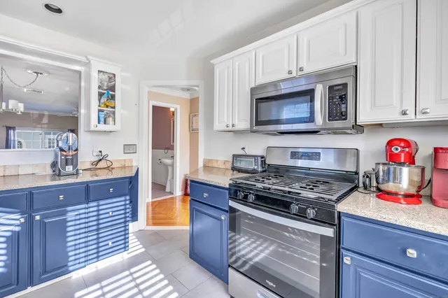 a kitchen with stainless steel appliances granite countertop a stove microwave and cabinets