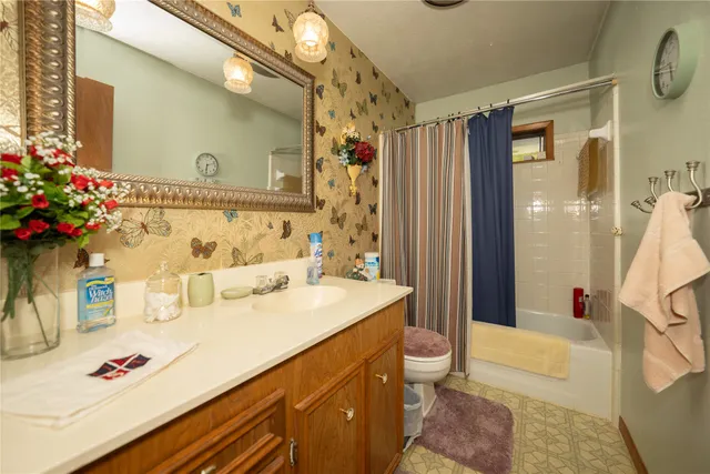 a living room with furniture a flat screen tv and a floor to ceiling window