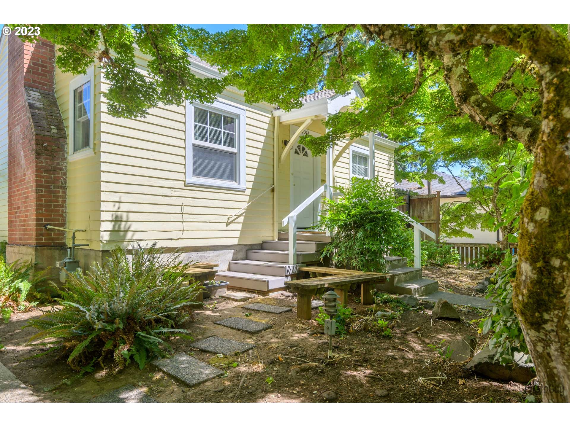 1041 Madison Street Eugene, OR 97402 - Photo 4 of 34 a backyard of a house with plants and large trees