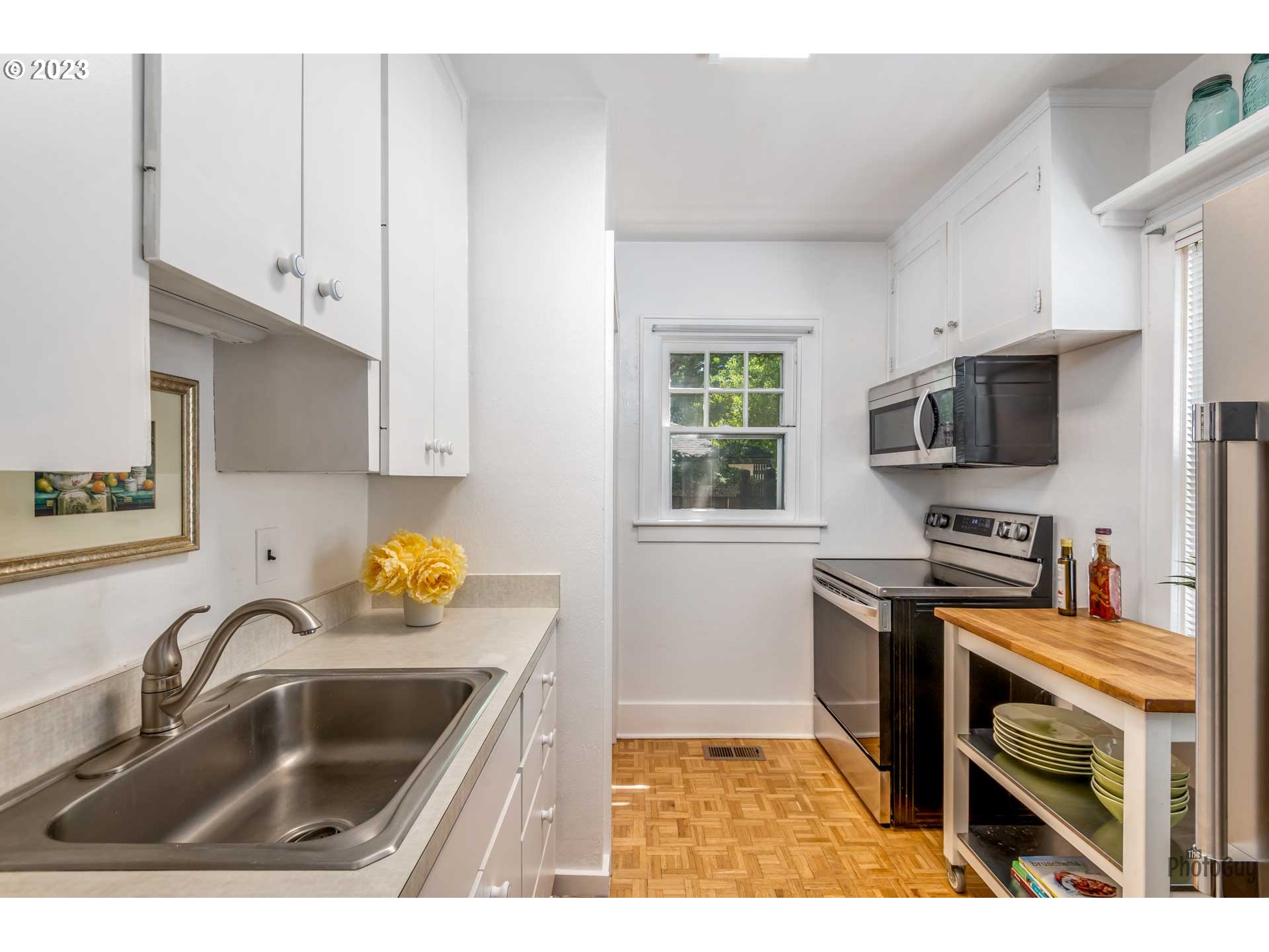 1041 Madison Street Eugene, OR 97402 - Photo 10 of 34 a kitchen with stainless steel appliances a sink a stove a microwave a sink a refrigerator and window