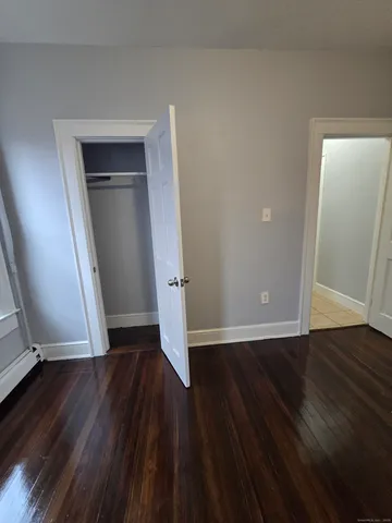an empty room with wooden floor and entrance