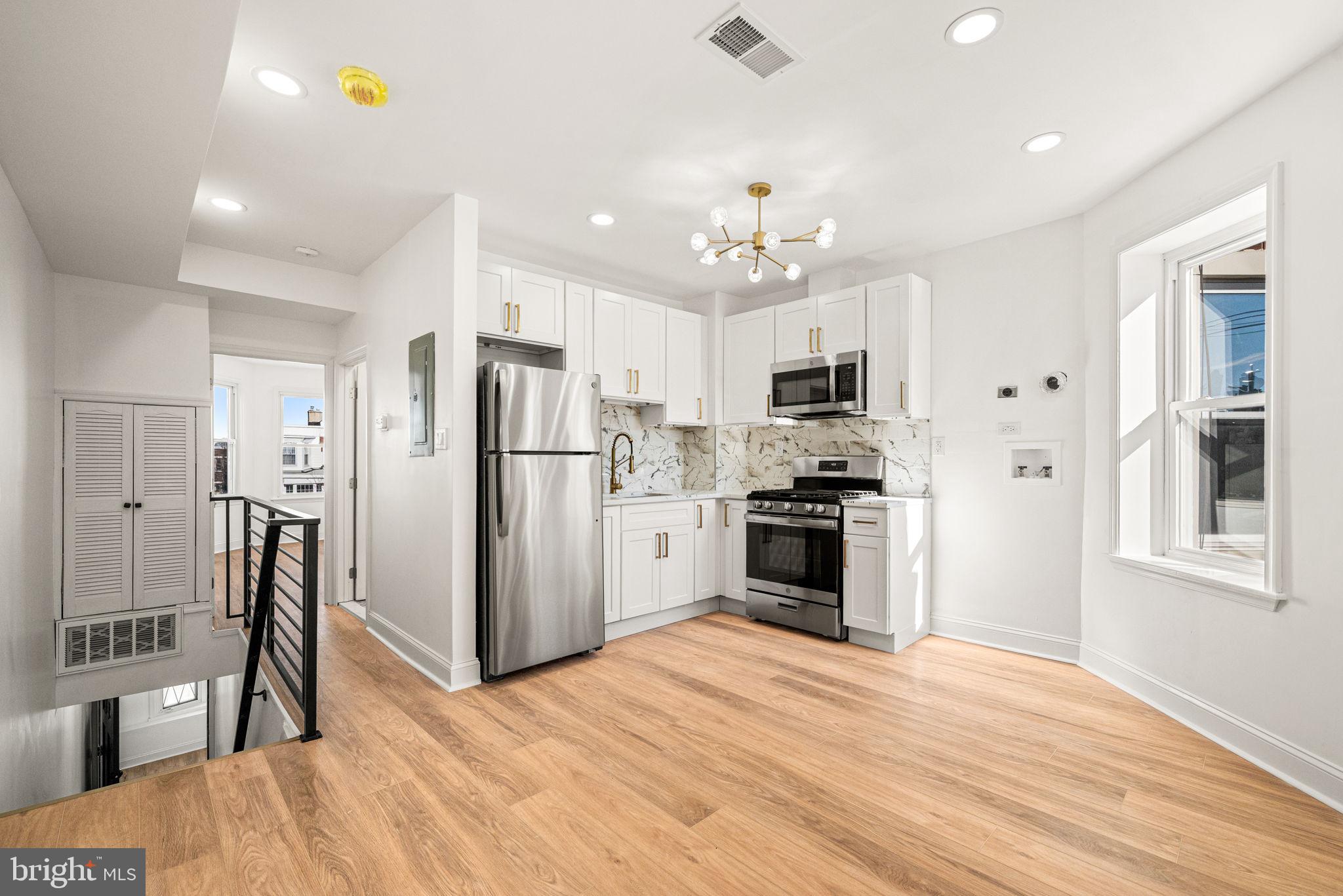 a kitchen with stainless steel appliances kitchen island granite countertop a refrigerator stove top oven and cabinets
