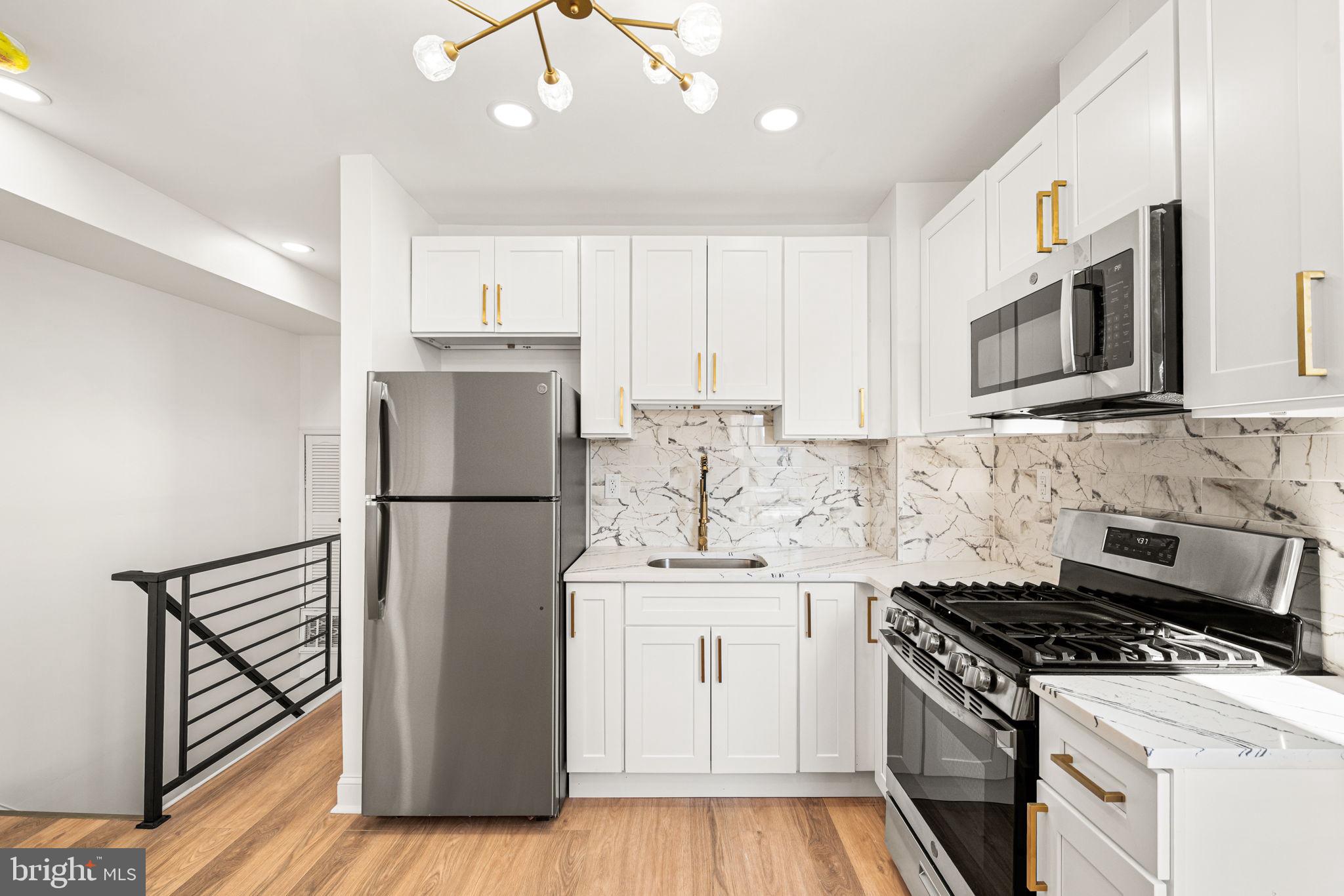 6128 Chestnut Street Philadelphia, PA 19139 - Photo 5 of 10 a kitchen with a sink a stove and refrigerator