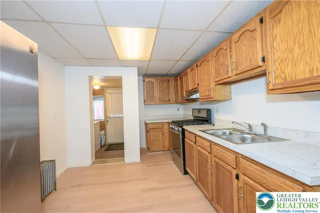 a kitchen with stainless steel appliances granite countertop a sink a stove and a refrigerator