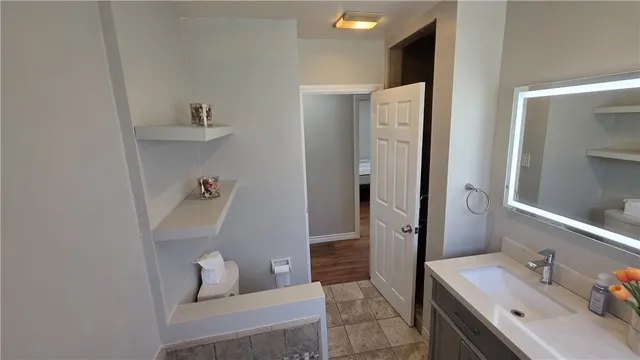 a bathroom with a sink and mirror with toilet