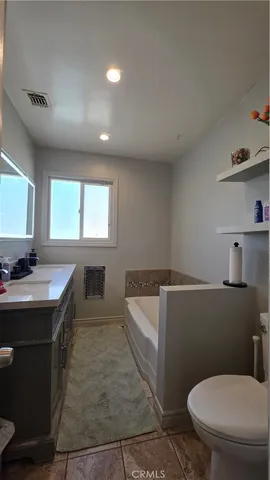 a bathroom with a sink a toilet a mirror and window