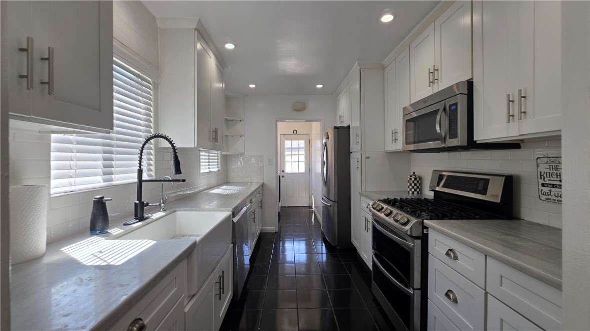 6637 Capps Avenue Reseda, CA 91335 - Photo 9 of 23 a kitchen with granite countertop a sink stainless steel appliances and cabinets