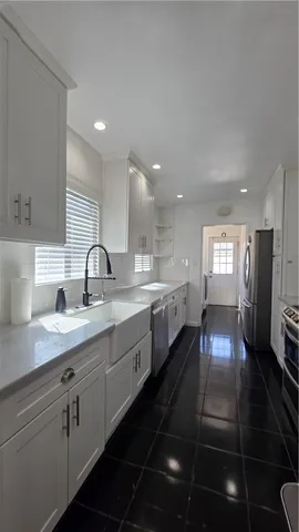 a large kitchen with stainless steel appliances a large counter top