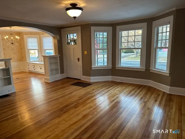 an empty room with wooden floor and a fireplace