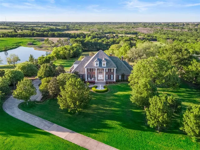 an aerial view of a house with a yard and lake view