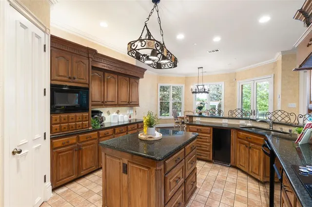 a kitchen with granite countertop a sink stove and cabinets