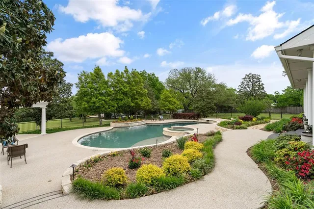 a view of a swimming pool with outdoor seating and plants