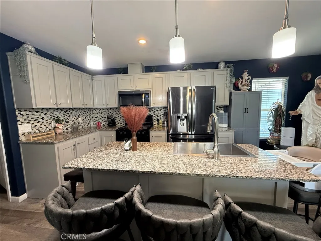 12700 Elliott, Unit 10 El Monte, CA 91732 - Photo 10 of 30 a kitchen with granite countertop kitchen island stainless steel appliances a sink stove and refrigerator