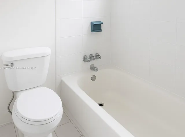 a white toilet sitting next to a bath tub