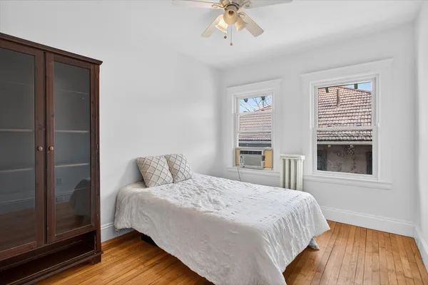 a bedroom with a bed and wooden floor