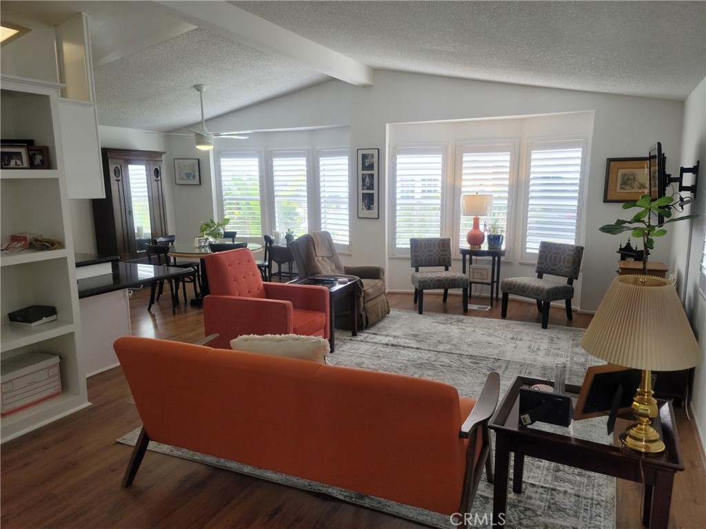 a living room with furniture wooden floor and a large window