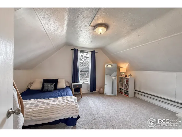 a backyard of a house with large trees and outdoor seating