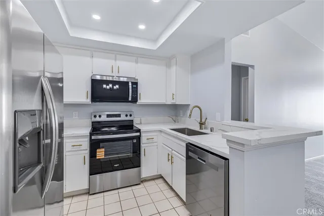 a kitchen with stainless steel appliances a refrigerator a stove a microwave a sink and a refrigerator