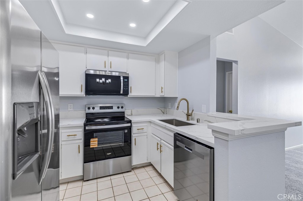 78 Costero Aisle, Unit 301 Irvine, CA 92614 - Photo 13 of 38 a kitchen with stainless steel appliances granite countertop a sink stove and refrigerator