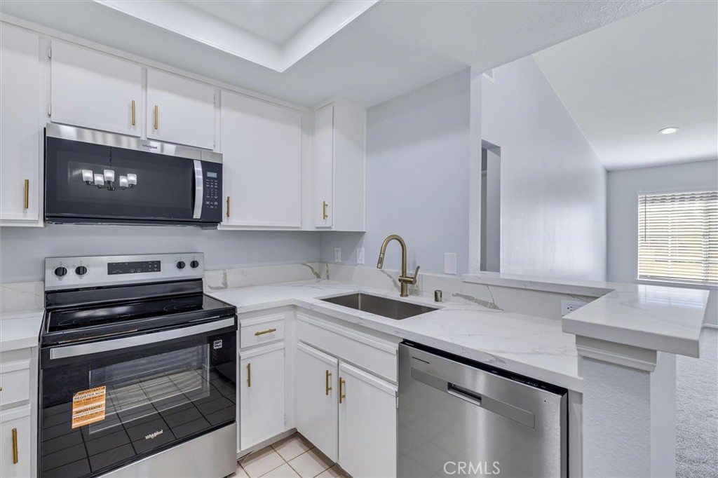 78 Costero Aisle, Unit 301 Irvine, CA 92614 - Photo 14 of 38 a kitchen with a sink stove and microwave