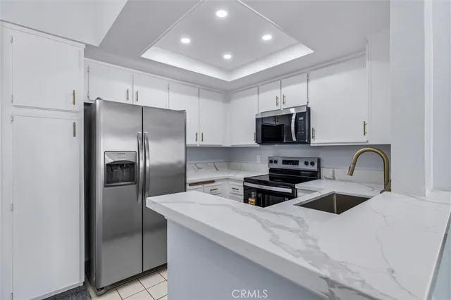 a view of a kitchen with a sink and dishwasher a stove top oven with a rug