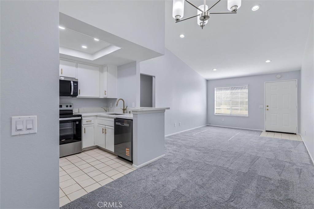 78 Costero Aisle, Unit 301 Irvine, CA 92614 - Photo 17 of 38 a view of a kitchen with a sink and dishwasher a stove top oven with a rug