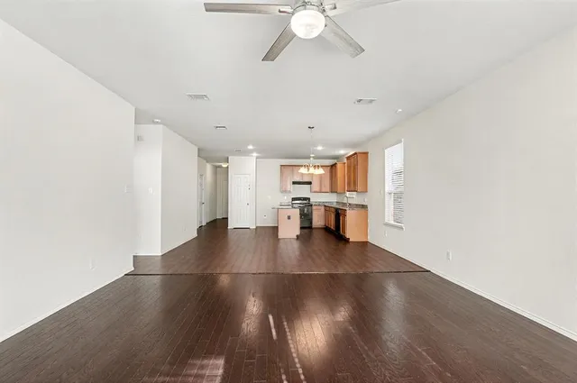 a view of a kitchen with a fridge and wooden floor